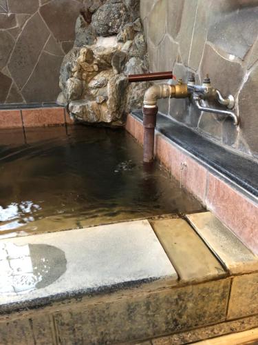 una fuente de agua en una piscina de agua en Private Beppu Tanoyu Onsen, en Beppu