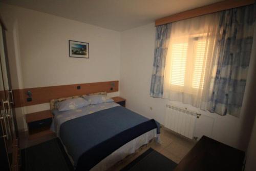 ein kleines Schlafzimmer mit einem Bett und einem Fenster in der Unterkunft Apartments by the sea Zlarin - 14025 in Zlarin