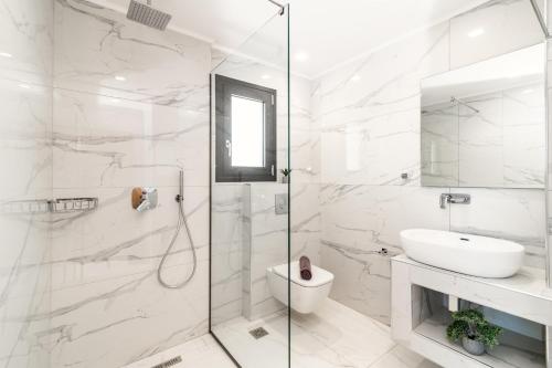 a white bathroom with a shower and a sink at Eagle's Nest - Adjoining Villas! in Tsilivi