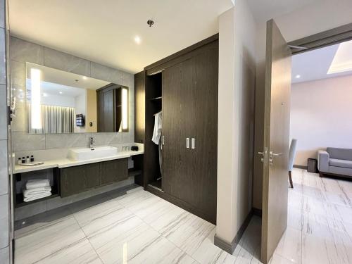 ein Bad mit einem Waschbecken und einem Spiegel in der Unterkunft Capitol Hill Hotel and Suites in Angeles