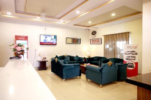 a living room with blue couches and a tv at Royalton Inn Hotel - Gulberg in Lahore