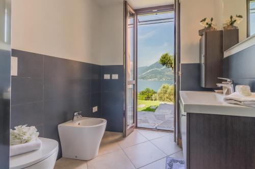 Un baño con inodoro, lavabo y ventana. en Varenna La Bomboniera, en Varenna