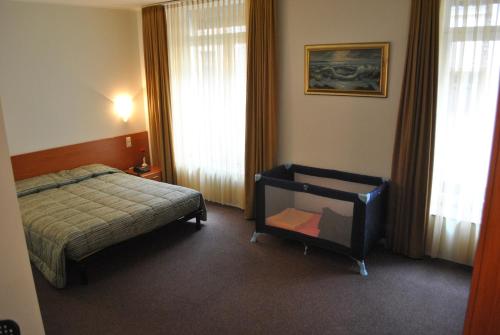 a bedroom with a bed and a chair in it at Auberge Gaglioti in Luxembourg