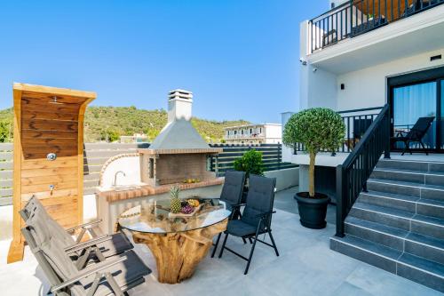 a patio with a table and chairs on a balcony at Eagle's Nest - Adjoining Villas! in Tsilivi