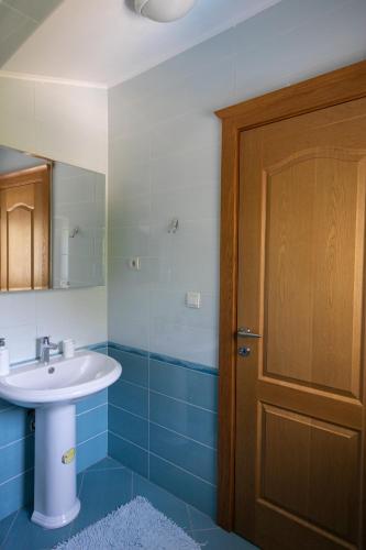 a bathroom with a sink and a wooden door at Villa Sveta in Petrovac na Moru