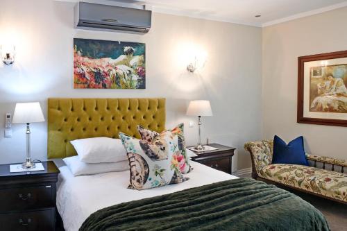 um quarto com uma cama e um sofá em Le Petit Bijou Boutique Apartments - Solar Power em Franschhoek