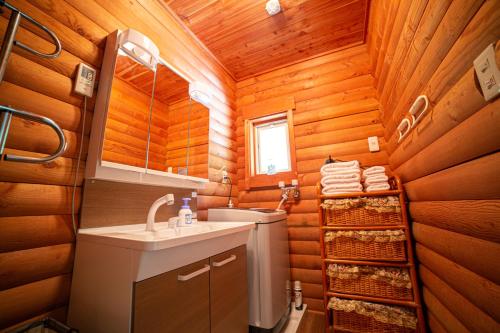 嬬戀的住宿－月の街60号北軽井沢，浴室设有木墙、水槽和镜子