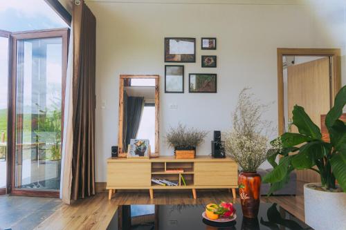 a living room with a mirror and a wooden dresser at Thỏ Non Garden Villa Bảo Lộc in Bao Loc