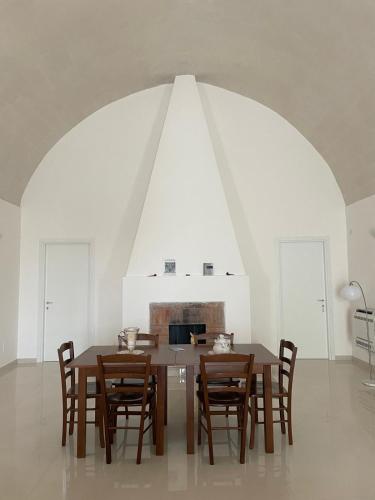 a dining room with a wooden table and chairs at Antica Masseria Malvezzi in Matera