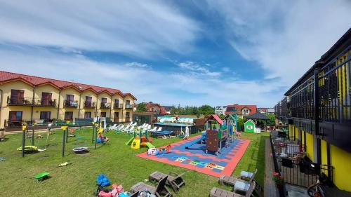 un parque con parque infantil y equipo de juegos en Willa Kwiatano - Plac zabaw & Jacuzzi & Basen & Sauna en Grzybowo