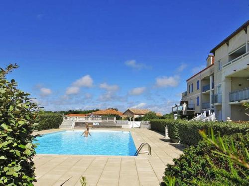 une femme se baignant dans une piscine dans une maison dans l'établissement Maison 3 pièces près de la plage avec piscine, terrasse, et parking à Bretignolles-sur-Mer. - FR-1-224A-17, à Bretignolles-sur-Mer