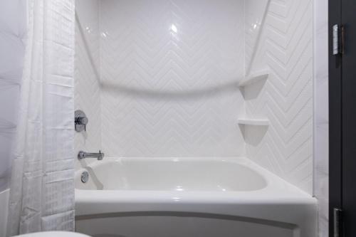 a white bathroom with a tub and a toilet at Holiday Inn Newark International Airport in Newark