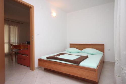 1 dormitorio con 1 cama con cabecero de madera en Apartments by the sea Drvenik Donja vala, Makarska - 6675, en Drvenik
