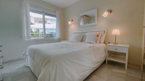 una camera bianca con un letto bianco e una finestra di Estrelicia III a Marbella