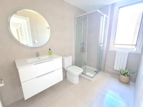 ein Badezimmer mit einem WC, einem Waschbecken und einem Spiegel in der Unterkunft Apartamento Nicores Bidasoa in Irún