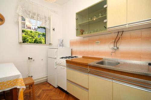 kuchnia ze zlewem i białą lodówką w obiekcie Apartments with a parking space Jelsa, Hvar - 8698 w mieście Jelsa