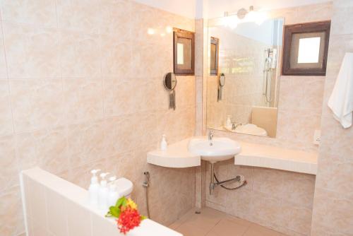 蘇梅島的住宿－Satva Samui Yoga and Wellness Resort，一间带水槽、浴缸和镜子的浴室