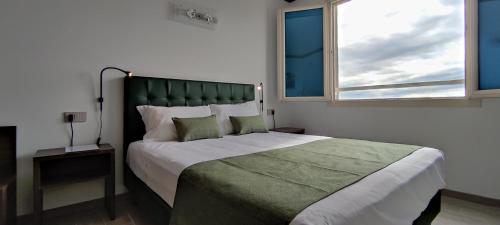 a bedroom with a large bed with a large window at Suites Direzionale Carpi in Carpi