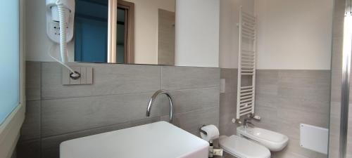 a bathroom with a white toilet and a mirror at Suites Direzionale Carpi in Carpi