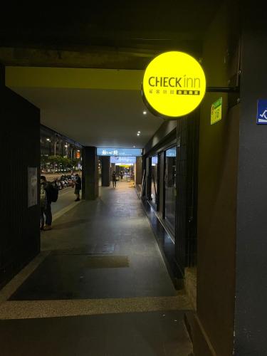a yellow sign hanging from the side of a building at CHECK inn Taipei Nanjing in Taipei