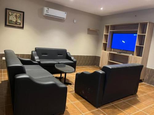 a waiting room with black chairs and a tv at Hotel & Resort Golden Marina Yanbu in Yanbu