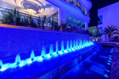 Tasia Maris Oasis في أيا نابا: حمام سباحة بأضواء زرقاء أمام مبنى