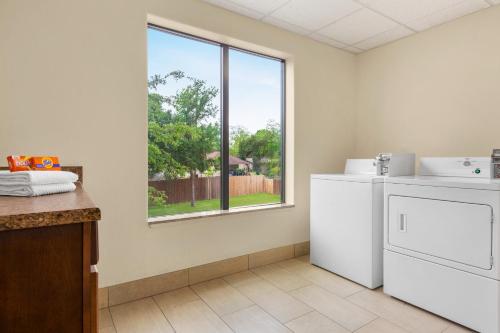 a laundry room with a washing machine and a window at Holiday Inn Express Hotel & Suites San Antonio NW-Medical Area, an IHG Hotel in San Antonio