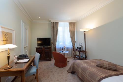 a hotel room with a bed and a desk at Suvretta House in St. Moritz