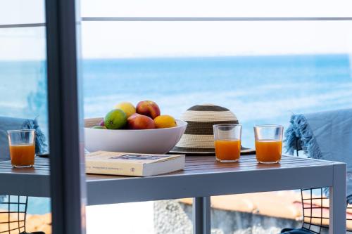 Aiora Suites by Booking Kottas في بساكوديا: طاولة مع وعاء من الفاكهة ووعاء من العصير
