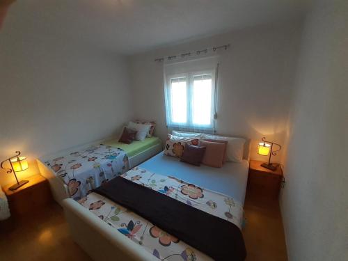 duas camas num pequeno quarto com duas lâmpadas em Apartments with a parking space Vodice - 13973 em Vodice