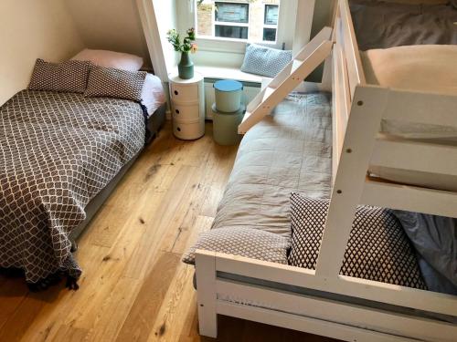 - une chambre avec des lits superposés et une échelle dans l'établissement Family Beach House Zandvoort City Center, à Zandvoort