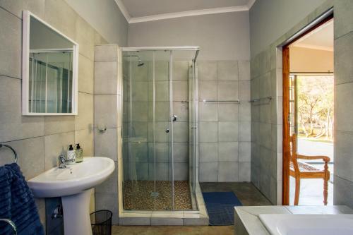 y baño con ducha y lavamanos. en Rivendell Trout Estate, en Lydenburg