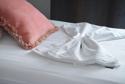 a pink pillow and a white robe on a bed at Lydia's Apartments in Kissamos