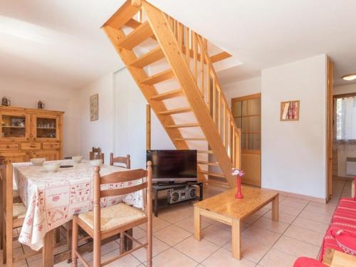 un salon avec une table et un escalier dans l'établissement Duplex cosy 6 pers. à Serre-Chevalier, Chantemerle - Balcon, Garage, Proche pistes - FR-1-330E-21, à Saint-Chaffrey