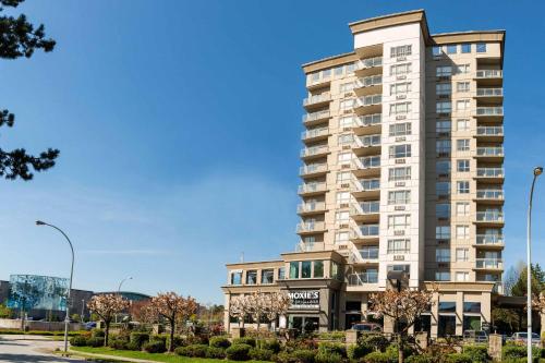 a tall apartment building on a street at Sandman Suites Surrey - Guildford in Surrey