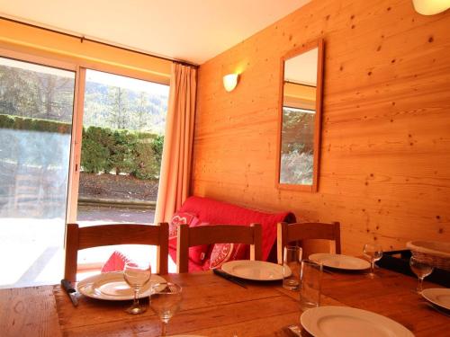 d'une salle à manger en bois avec une table, des chaises et une fenêtre. dans l'établissement Charmant T2 avec coin montagne, proche pistes et commerces, 6 couchages, terrasse, Serre Chevalier - FR-1-330E-104, à Saint-Chaffrey