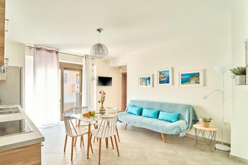 un soggiorno con divano blu e tavolo di Lydia's Apartments a Kíssamos