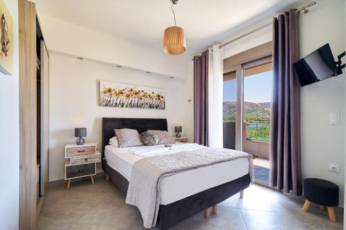 a bedroom with a bed and a large window at Lydia's Apartments in Kissamos