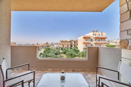 a balcony with a table and chairs and a large window at Lydia's Apartments in Kissamos