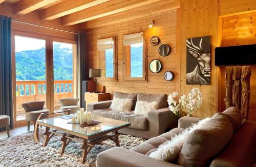 uma sala de estar com um sofá e uma mesa em Le Paret chambres d'hôtes de charme & spa em Manigod