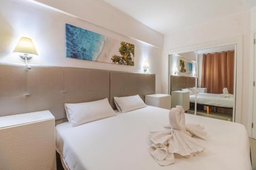 1 dormitorio con cama blanca con arco en Charming seaside and terasse in Playa paraiso, en Adeje