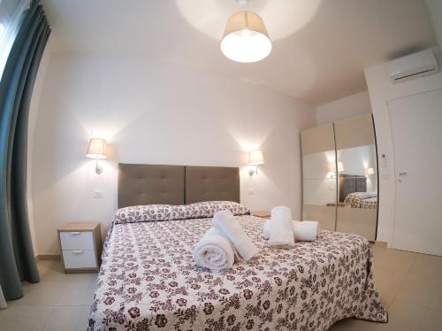 1 dormitorio con 1 cama con toallas en Residence Chanel, en Santa Maria di Castellabate
