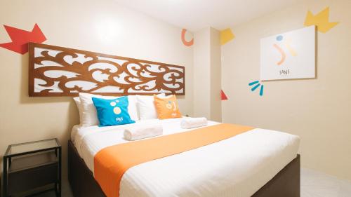 um quarto com uma cama grande e almofadas coloridas em Sans Hotel at Algers Suites Marikina by RedDoorz em Manilla