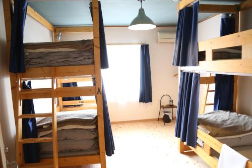 Zimmer mit Etagenbetten in einem Hostel in der Unterkunft PERCH GUEST HOUSE in Tatsuno