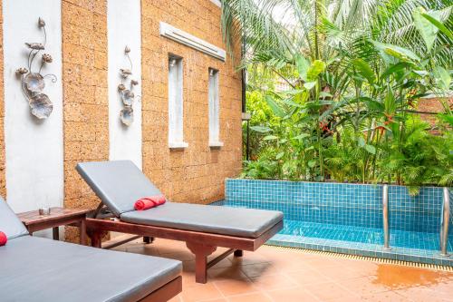a patio with two chairs and a swimming pool at Grange in Siem Reap