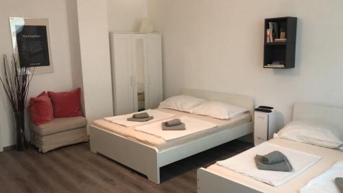 ein kleines Zimmer mit 2 Betten und einem Stuhl in der Unterkunft JA 12 Apartment in Budapest