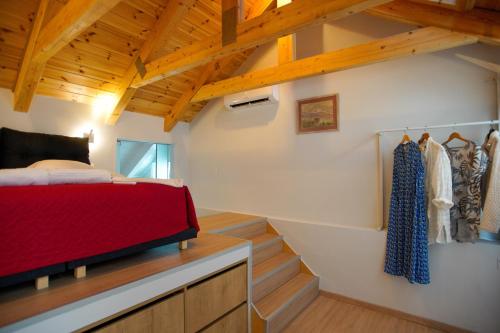 a bedroom with a red bed and a staircase at Seafalios Villa in Chania