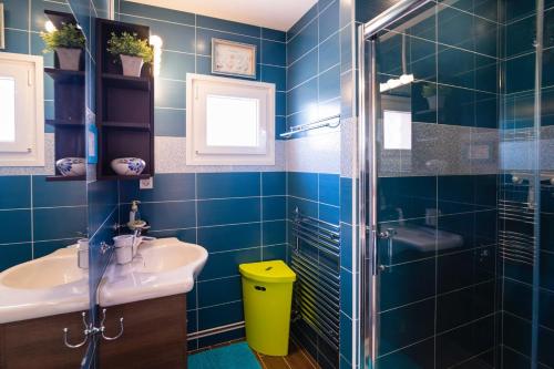 y baño de azulejos azules con lavabo y ducha. en Maison centre-ville avec jardin privé Jonzac, en Jonzac