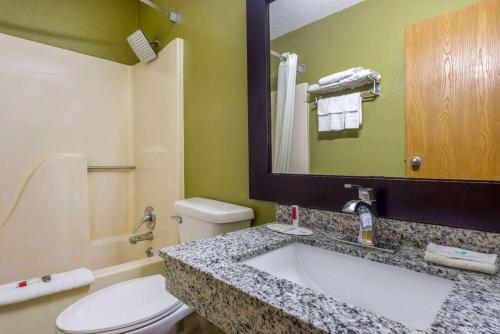 La salle de bains est pourvue de toilettes et d'un lavabo avec miroir. dans l'établissement Super 8 by Wyndham El Dorado, à El Dorado