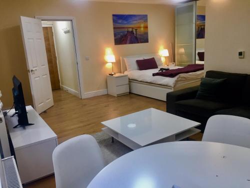 a living room with a couch and a table at Westminster House in Slough